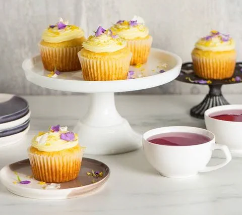 recipe image Petits gâteaux au citron avec glaçage à la fleur de sureau et fleurs comestibles